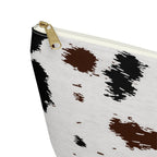 Close-up of the gold zipper pull on the black brown cow print makeup bag