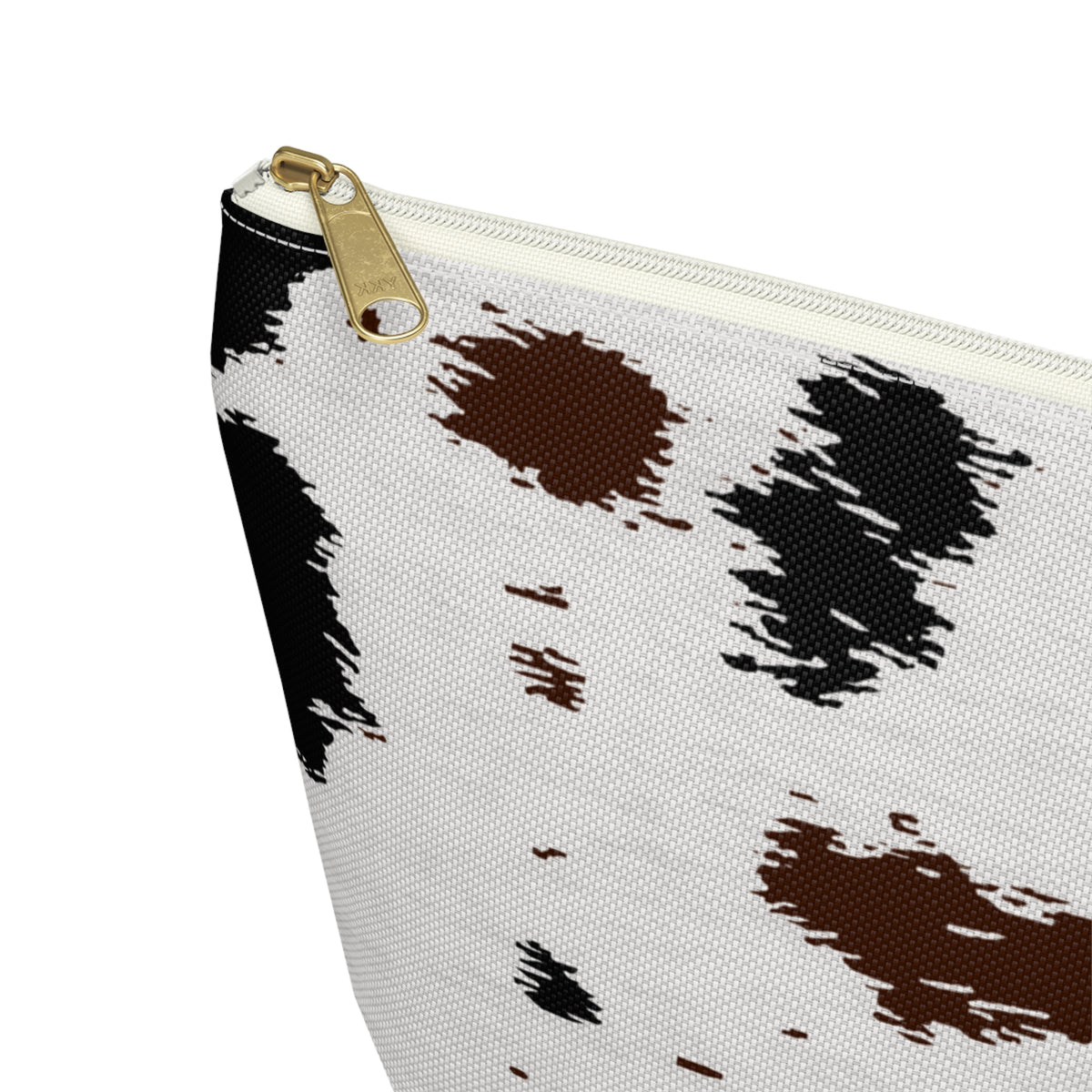 Close-up of the gold zipper pull on the black brown cow print makeup bag