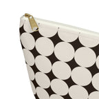 Close-up of the cream circle print on black and gold zipper pull on the makeup bag