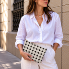 Model holding the Black Cream Geometric makeup bag like a clutch
