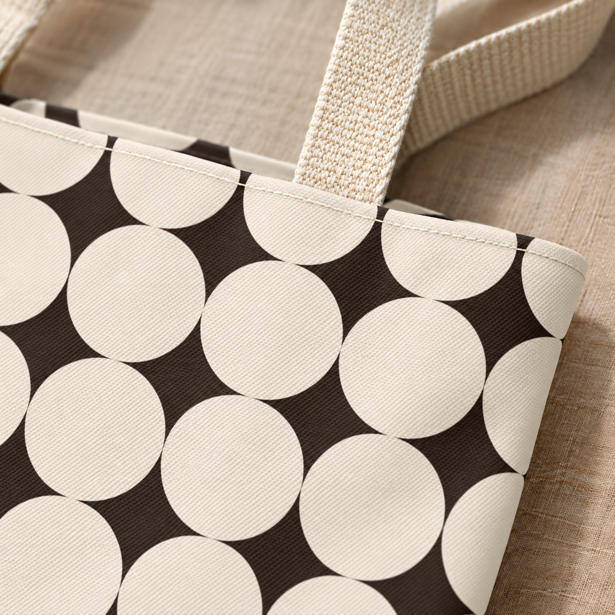 Close-up of the cream circles on black and the handle of the geometric tote bag