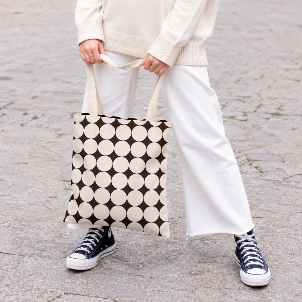 Model in white trousers carrying the retro Black Cream Geometric tote bag