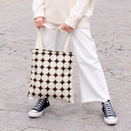 Model in white trousers carrying the retro Black Cream Geometric tote bag
