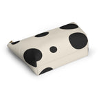 Black and cream polka dot cosmetic bag lying at an angle