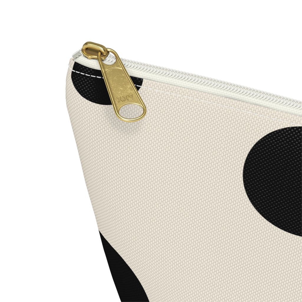 Close-up of the gold zipper pull on the black polka dot makeup bag