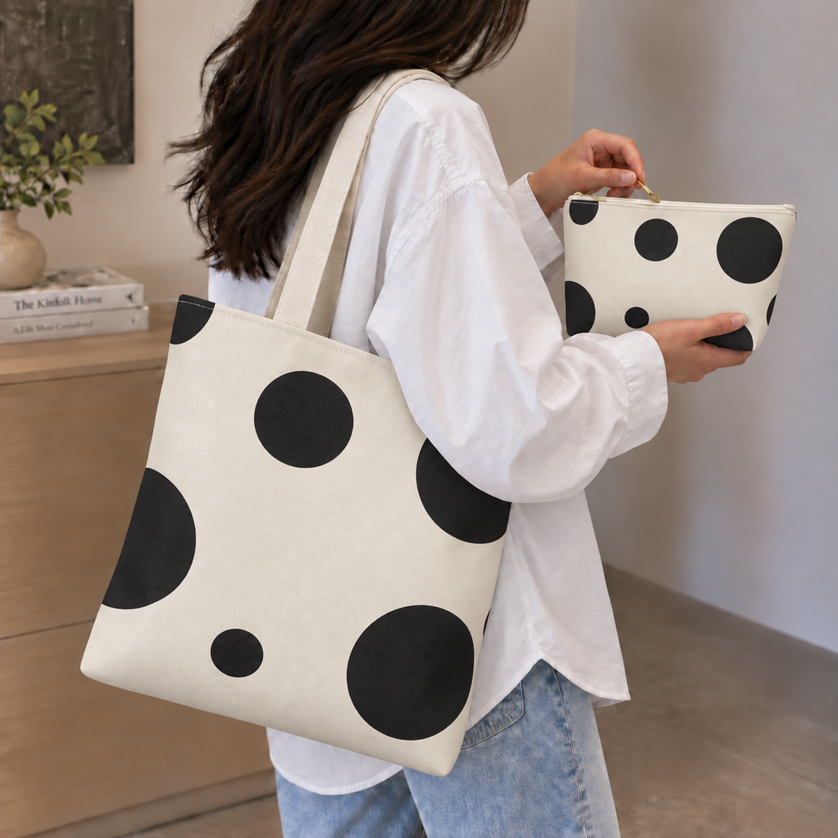 Model carrying the polka dot tote bag on her shoulder with the matching makeup bag in hand