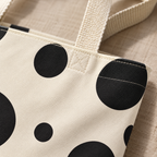Close-up of the black polka dots and cream handle of the tote bag