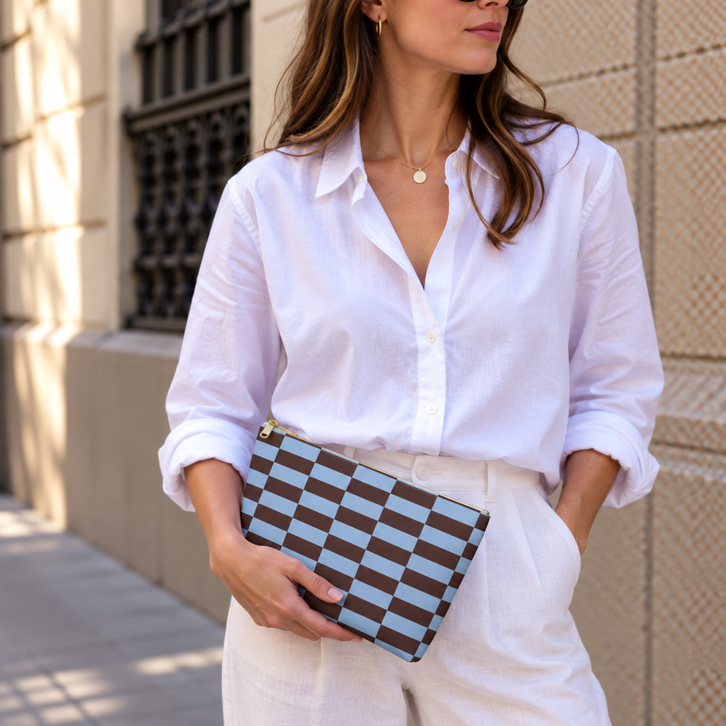 Woman in white shirt holding the blue brown brick makeup bag