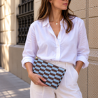 Woman in white shirt holding the blue brown brick makeup bag