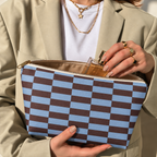 Hands holding the open blue brown brick makeup bag