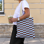 Side view of a person carrying the blue brown brick tote bag on the shoulder