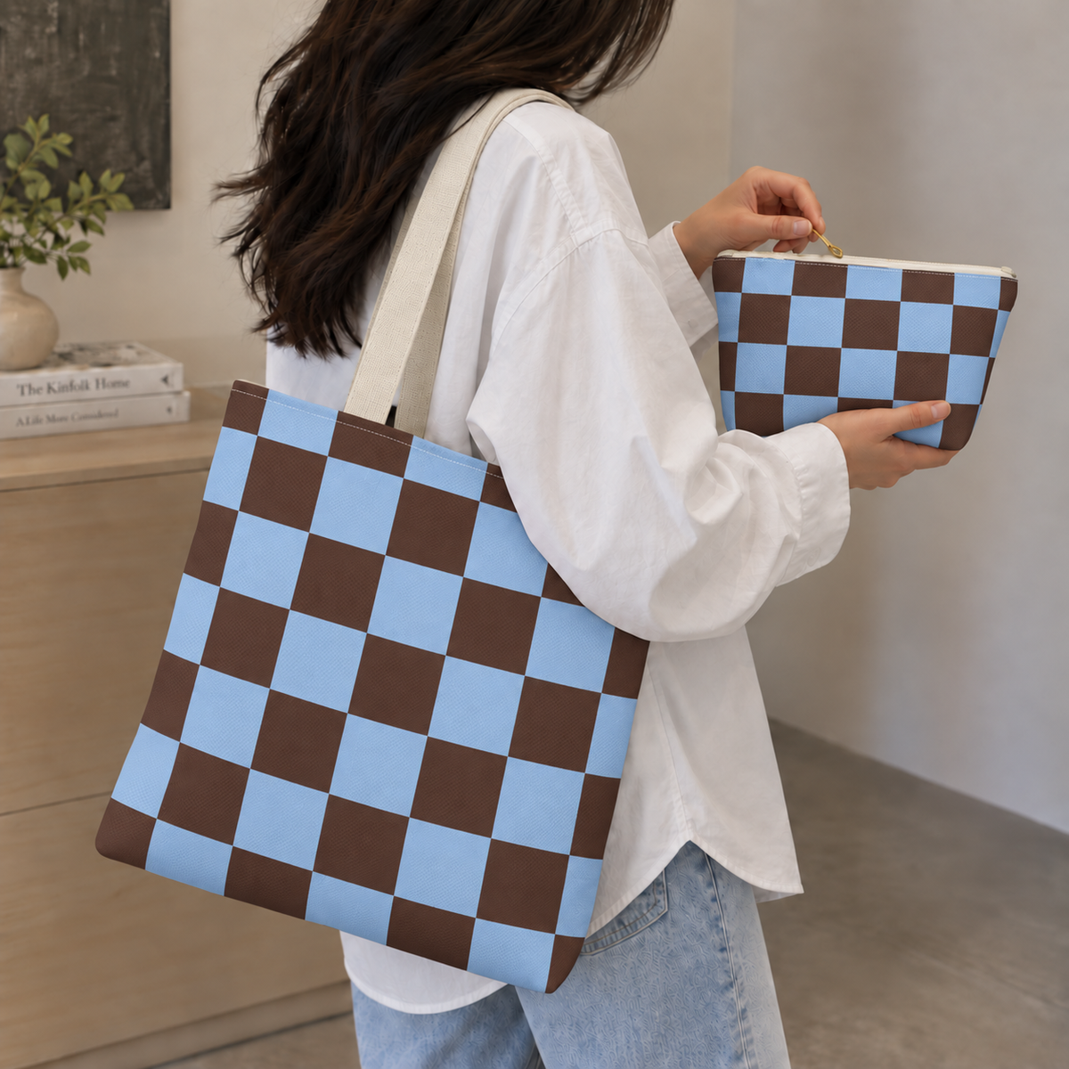 Woman carrying the blue brown checkered tote bag with the matching makeup bag in her hand