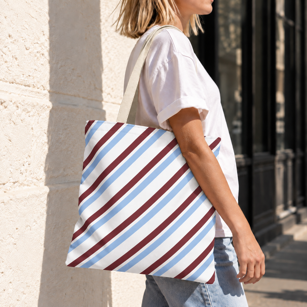 Model carrying the blue burgundy diagonal striped tote bag on the shoulder