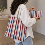 Woman carrying the blue burgundy dot striped tote bag with the matching makeup bag in her hand