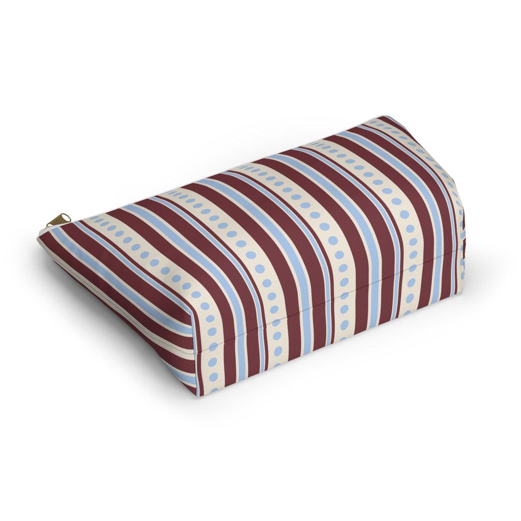 Blue burgundy dot striped makeup bag lying on its side showing the stripes and dots