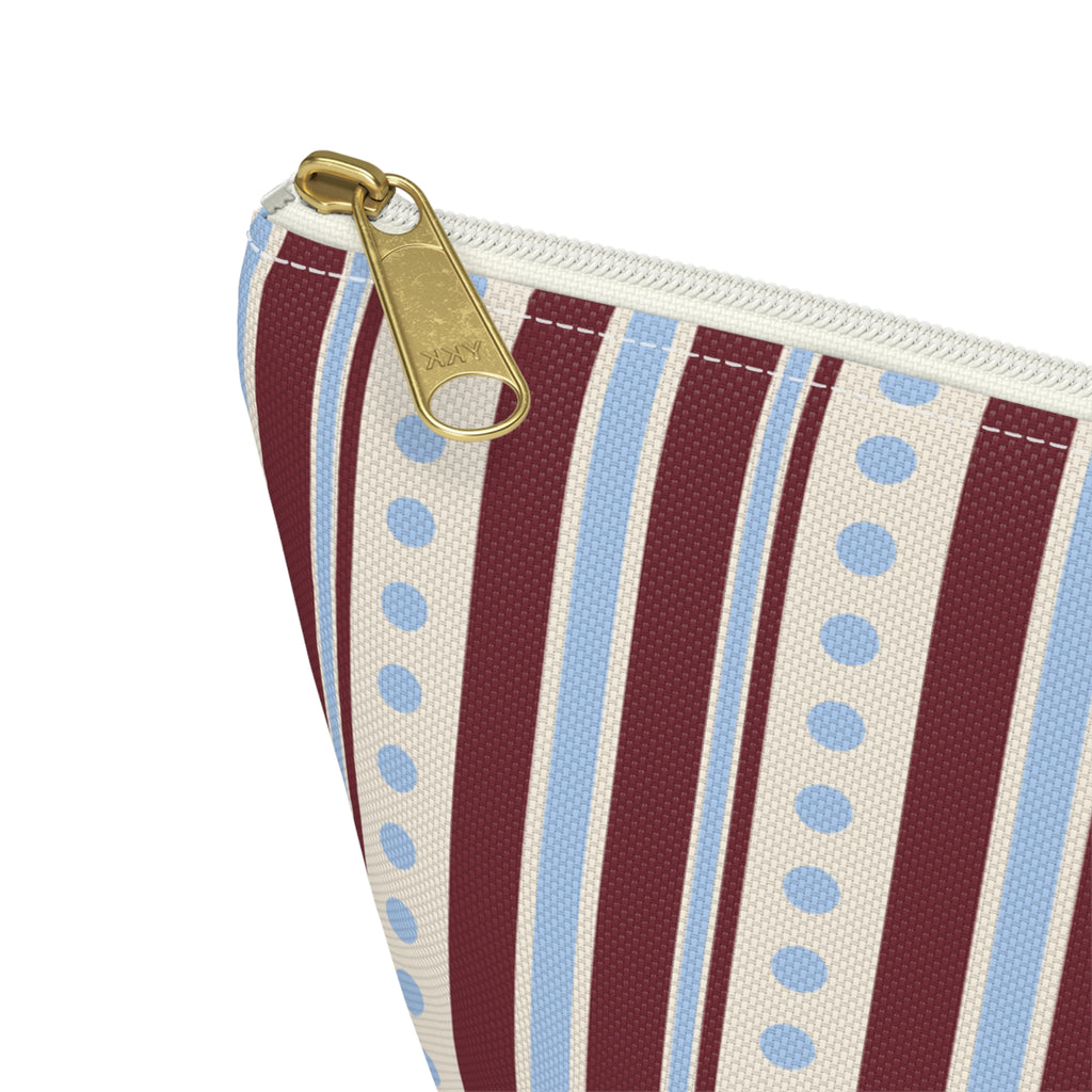 Close-up of the gold zipper pull and blue dotted stripes on the makeup bag