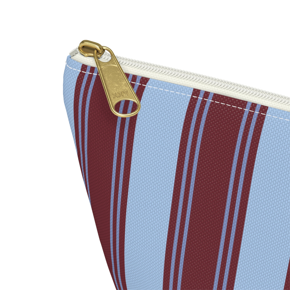 Close-up of the gold zipper pull on the striped makeup bag