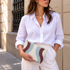 Model in a white shirt holding the blue burgundy wavy makeup bag at her waist