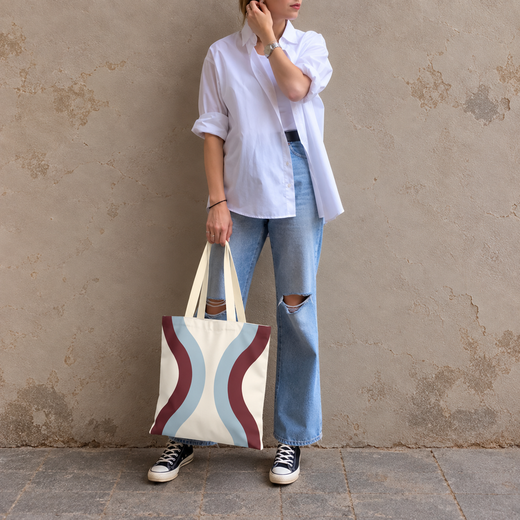 Model in jeans standing with the blue burgundy wavy tote bag in her hand