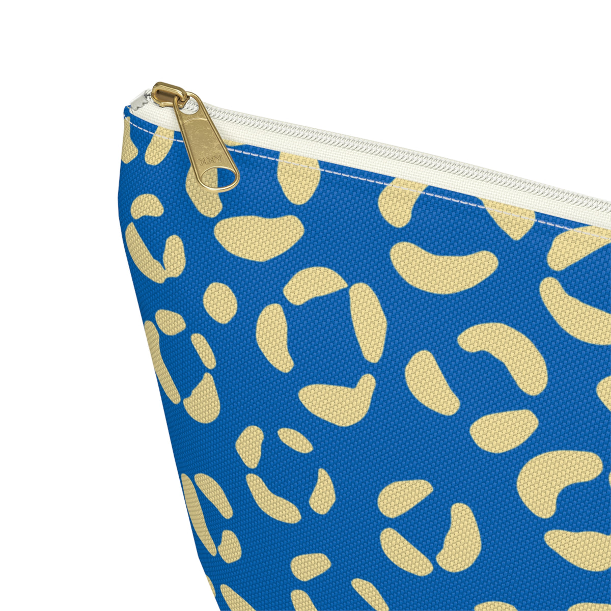 Close-up of the gold zipper pull and cream leopard spots on the makeup bag