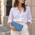 Woman in a white shirt holding the blue leopard print makeup bag as a clutch