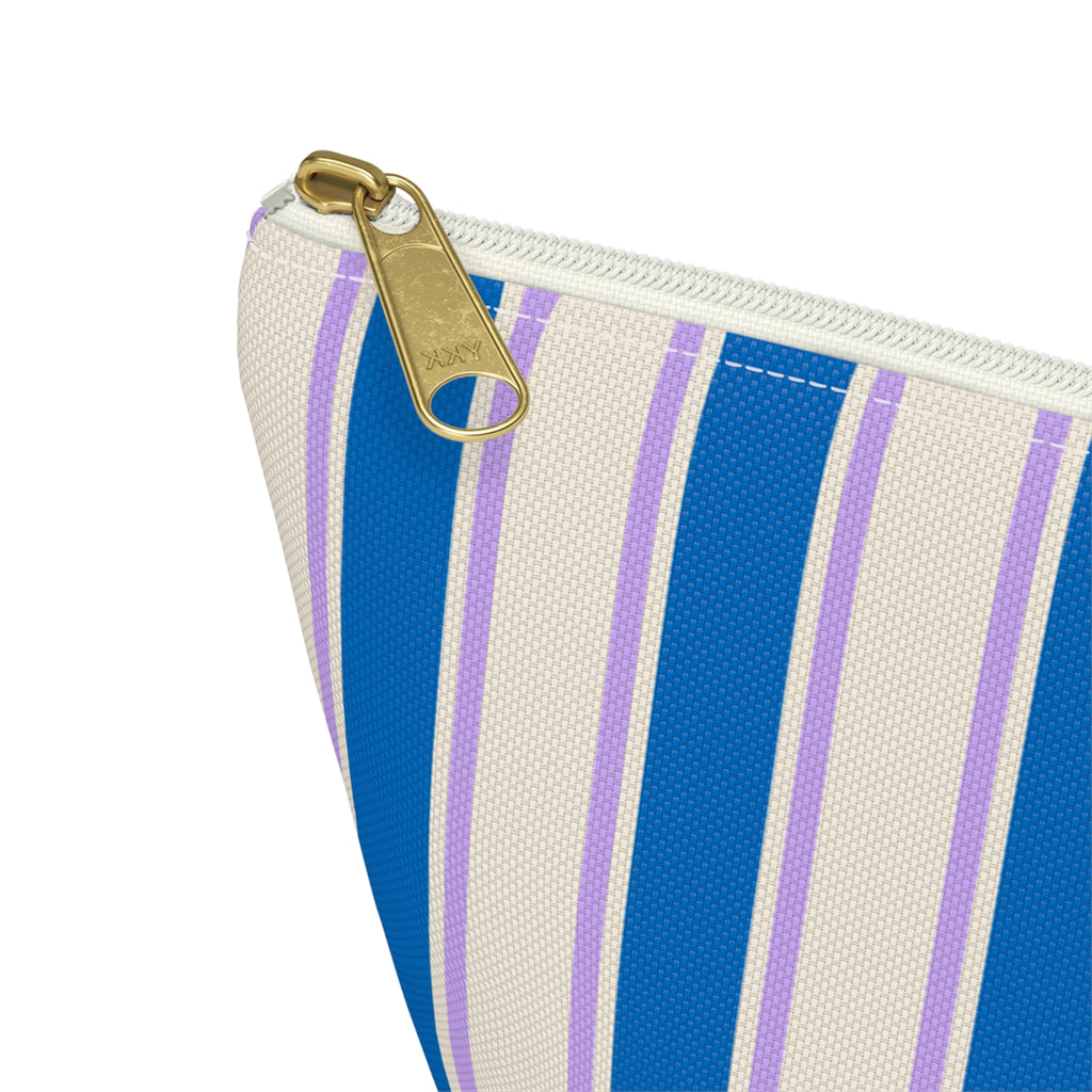 Close-up of the cobalt blue and cream stripes and gold zipper pull on the makeup bag