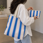 Model holding the Blue Cream Striped tote bag with the matching makeup bag