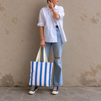 Full-length model photo with the Blue Cream Striped tote bag against a wall