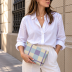 Model in a white shirt holding the blue lilac cream plaid makeup bag as a clutch