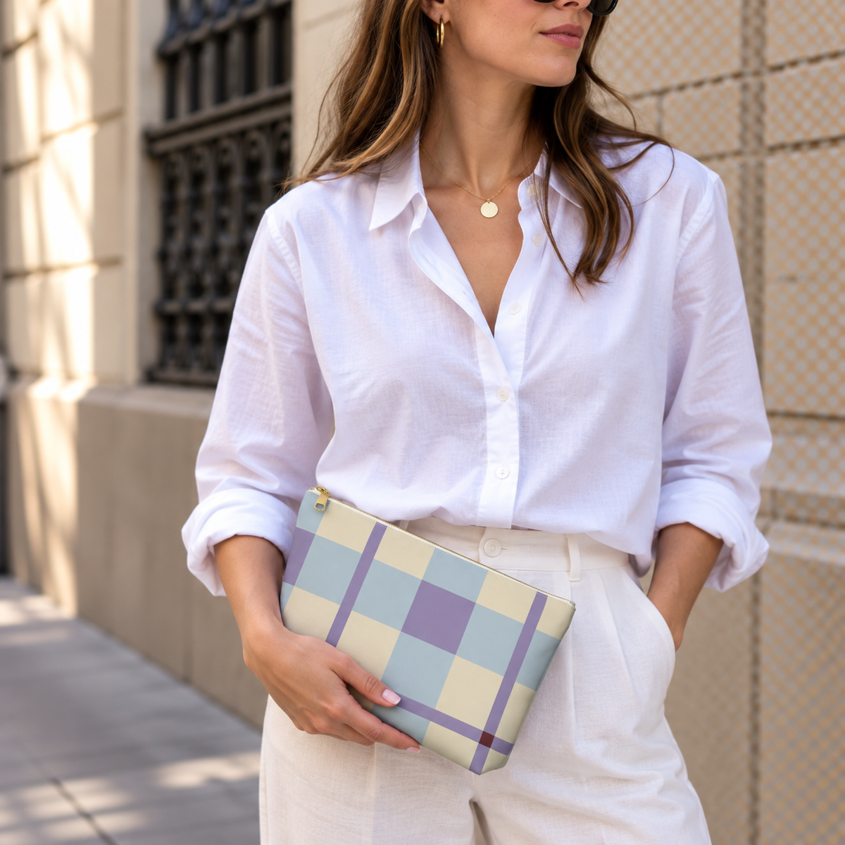 Model in a white shirt holding the blue lilac cream plaid makeup bag as a clutch