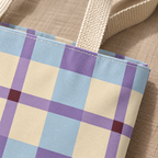 Close-up of the pastel blue, lilac and cream plaid and beige handle on the tote bag