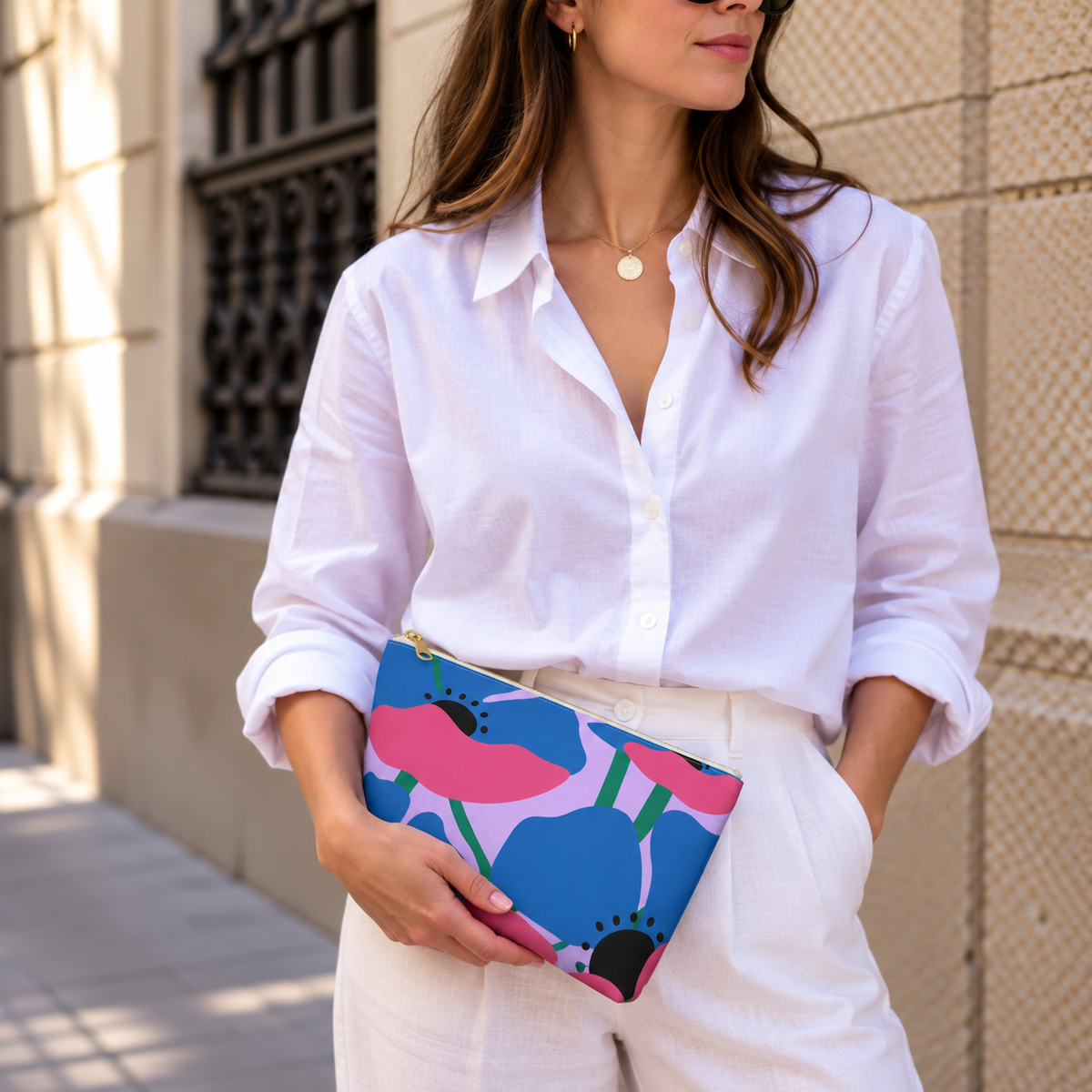 Model holding the blue pink poppy floral makeup bag like a clutch