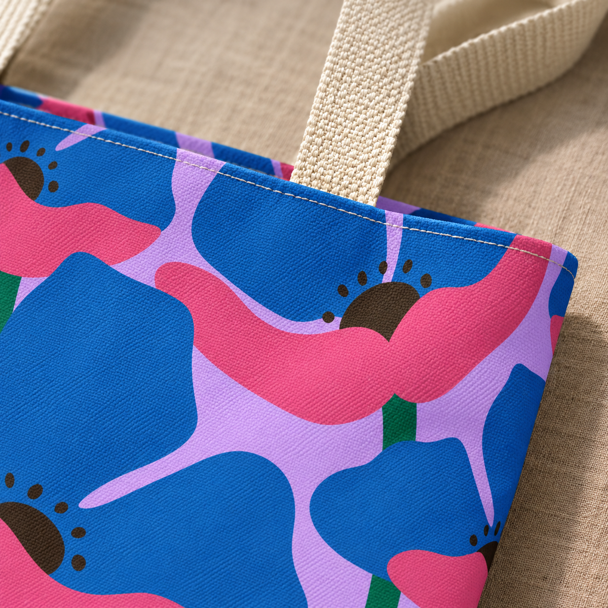 Close-up of the blue and pink poppies on lilac and the cream handle of the tote bag
