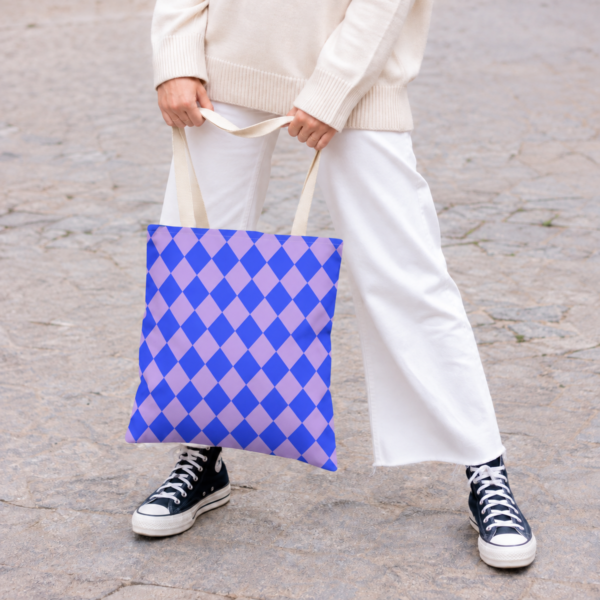 Woman in white trousers carrying the blue purple diamond checkered tote bag