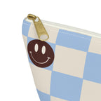 Close-up of the gold zipper pull on the blue smiley face checkered makeup bag