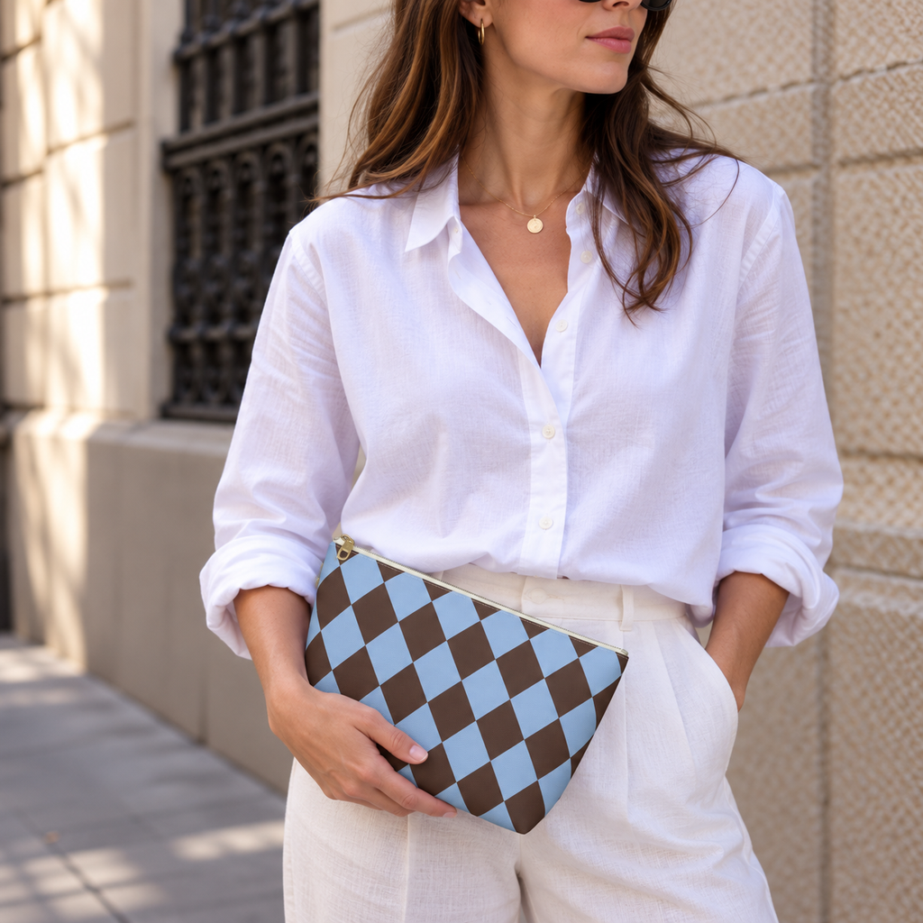 Woman in a white blouse holding a brown blue diamond checkered makeup bag