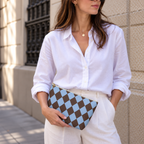 Woman in a white blouse holding a brown blue diamond checkered makeup bag