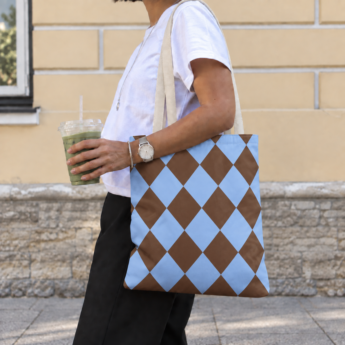 Woman walking with a brown blue diamond checkered tote bag over her shoulder