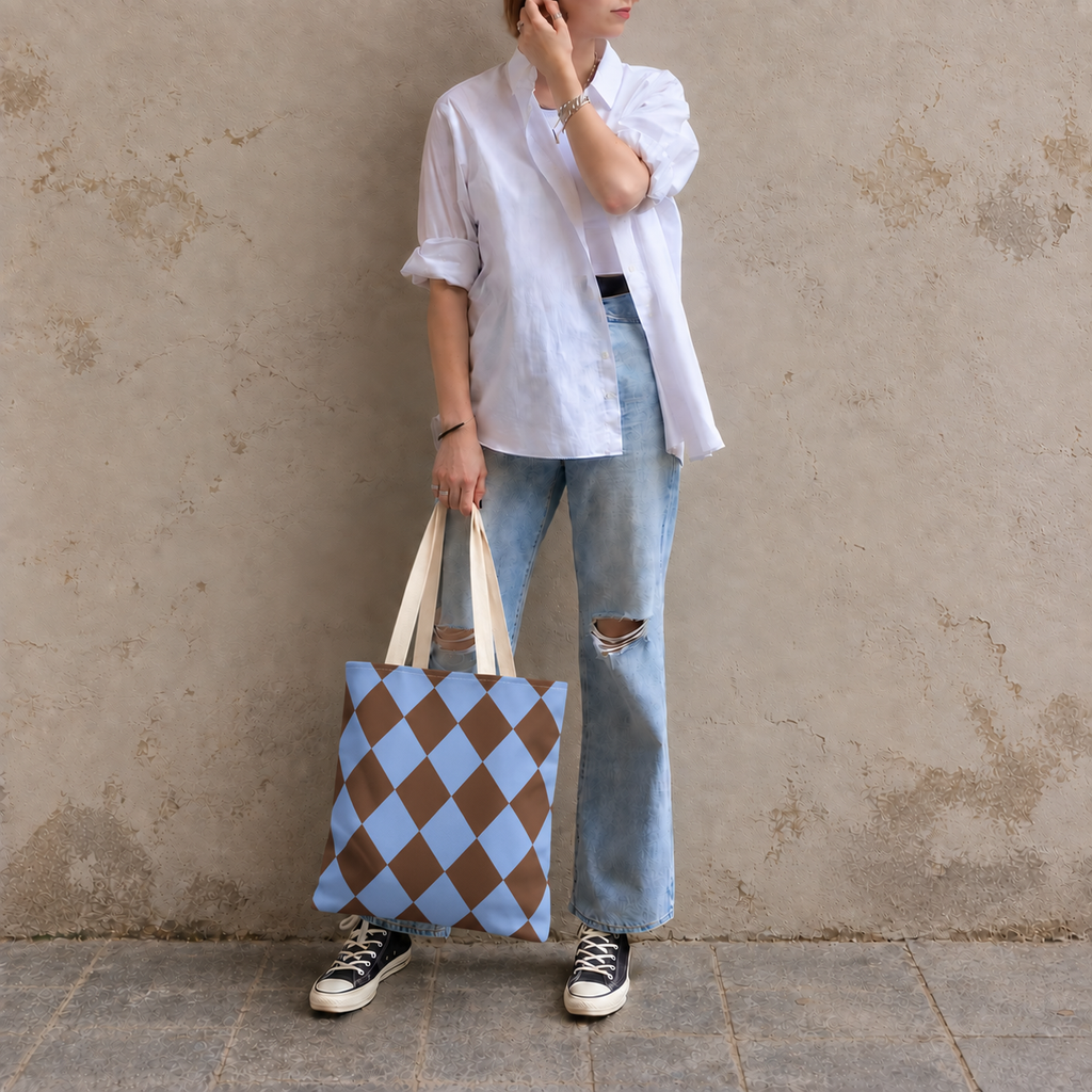 Woman leaning on a wall holding a brown blue diamond checkered tote bag