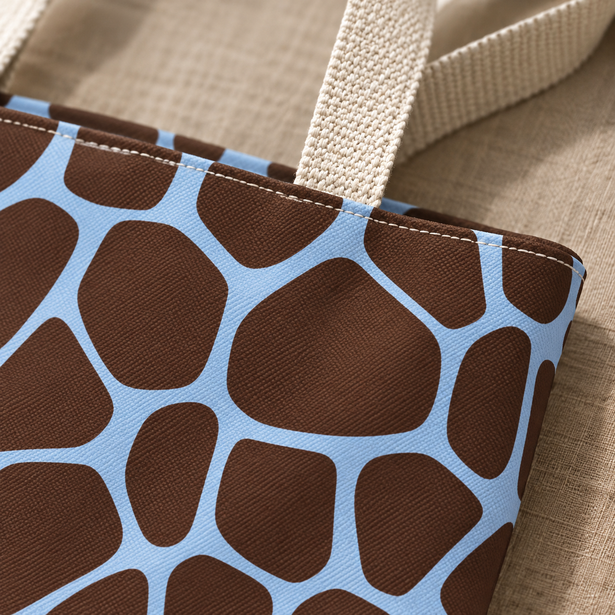 Close-up of brown giraffe patches with sky blue lines and the tote bag handle