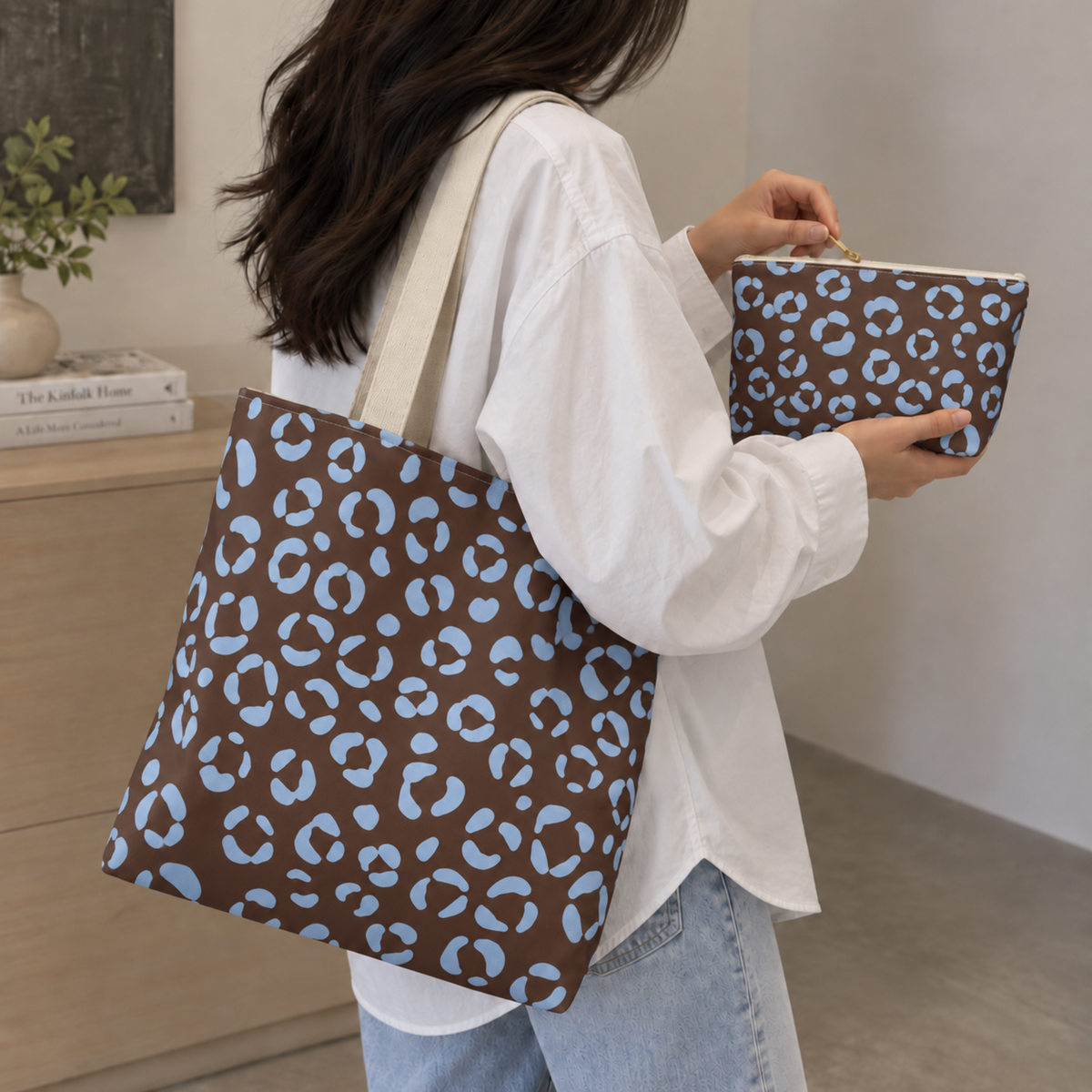 Woman carrying a brown blue leopard print tote bag and matching makeup bag