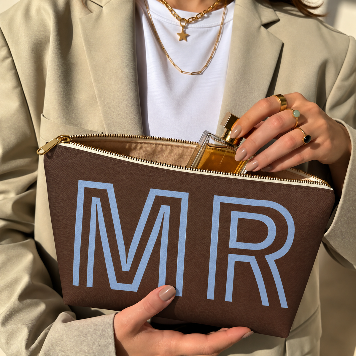 Hands holding the open brown MR personalized makeup bag