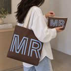 Woman carrying the brown blue monogram tote bag next to the matching makeup bag