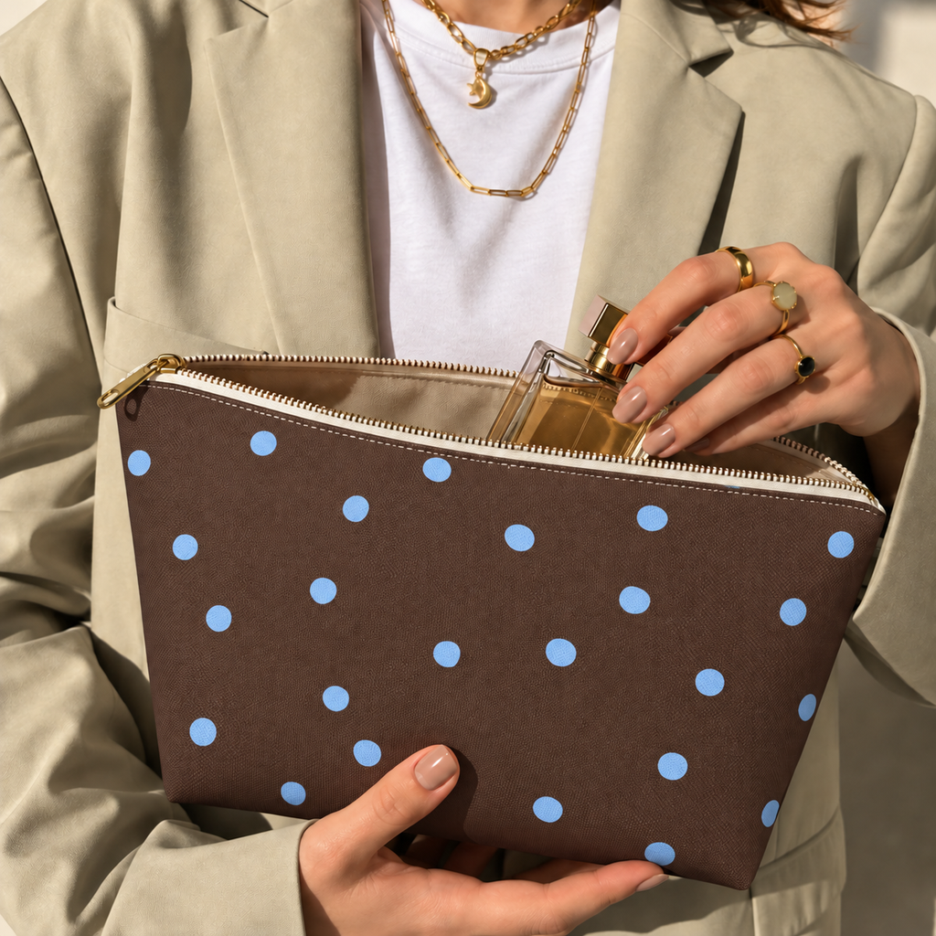 Woman opening the brown polka dot makeup bag to take out a perfume bottle