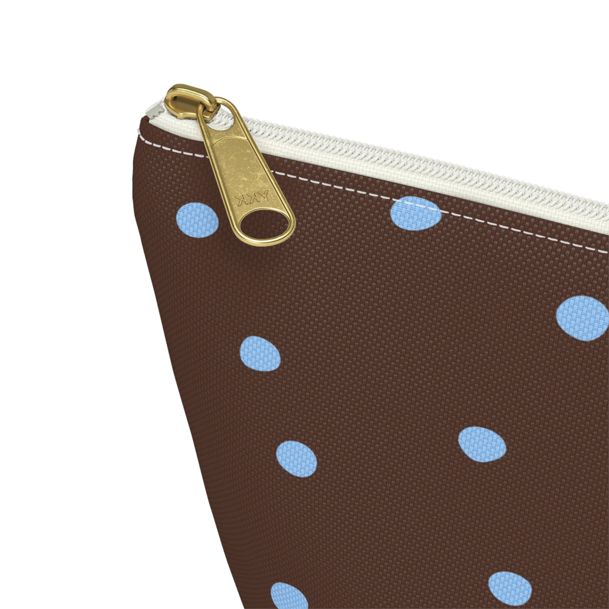 Close-up of the gold zipper pull on the brown blue polka dot makeup bag