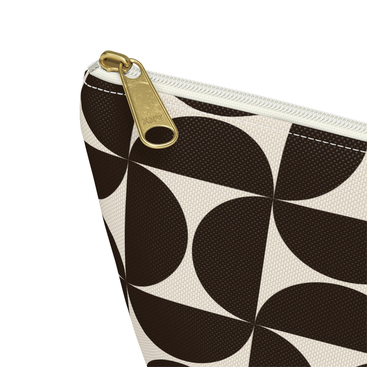 Close-up of the gold zipper pull and brown geometric print on the makeup bag