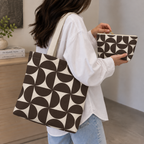 Woman carrying the brown cream geometric tote bag with the matching makeup bag in her hand