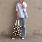 Woman in white shirt and jeans standing with the brown cream geometric tote bag