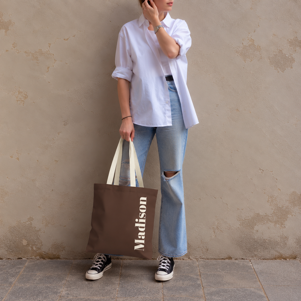 Model standing outdoors with the Brown Cream Name personalized tote bag in a full-body photo