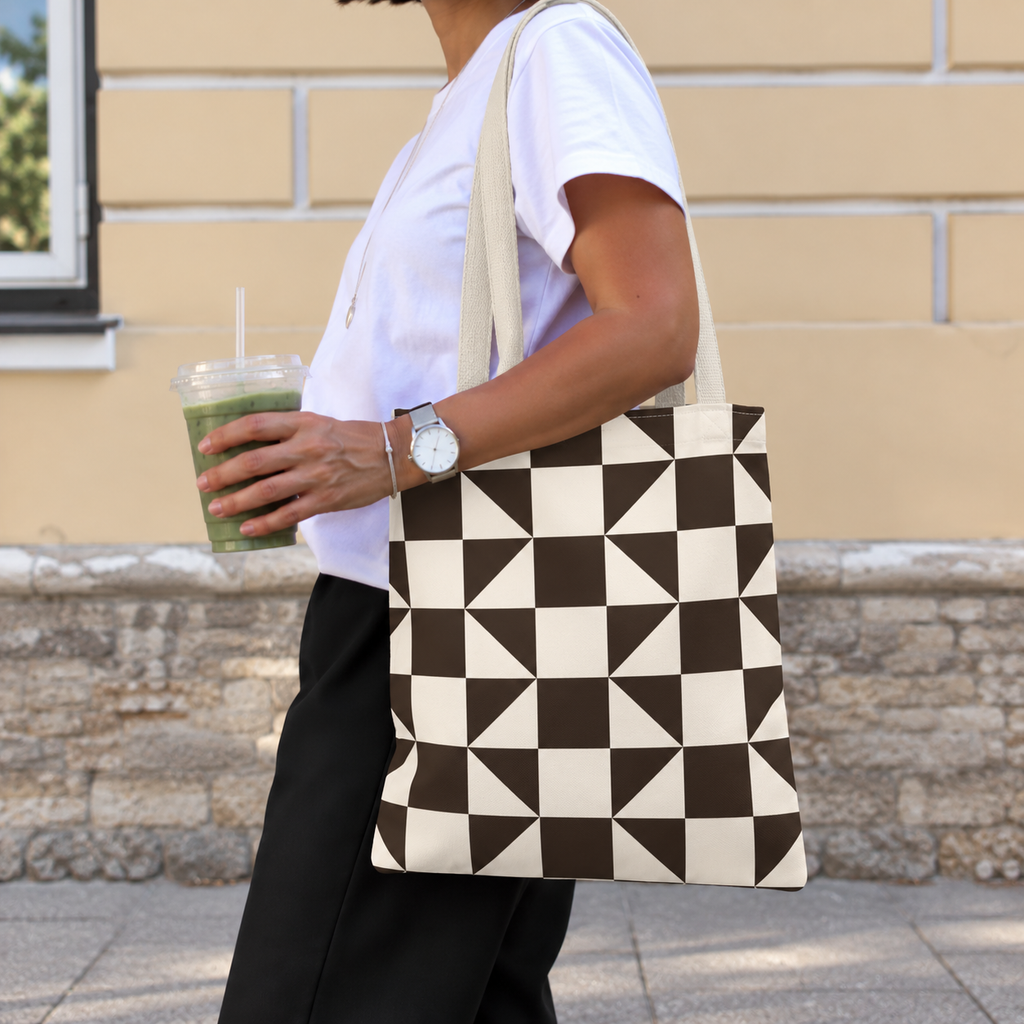 Side view of a person carrying the brown cream triangle tote bag on the shoulder